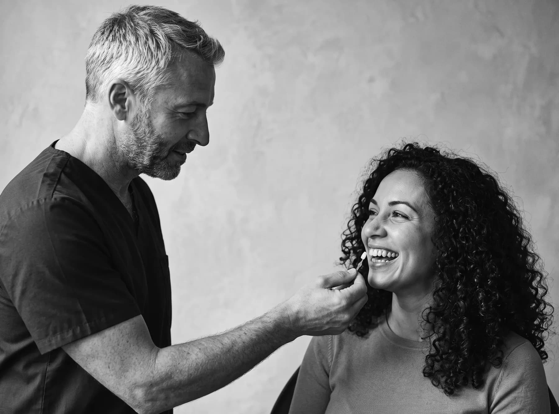 Ottoline: the dentist matching a shade against a patient's teeth, in black and white